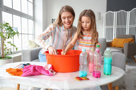 Little girl with her sister making tie-dye t-shirt at homeの写真素材