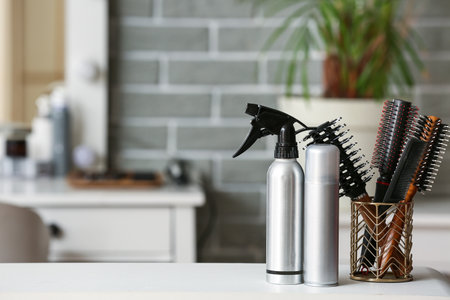Hair sprays and brushes on table in beauty salonの写真素材