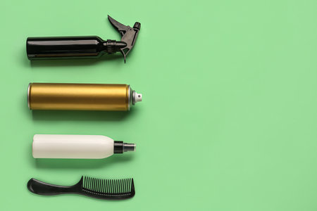 Bottles of hair sprays and comb on color backgroundの写真素材