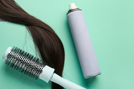 Bottle of hair spray, brush and strand on color backgroundの写真素材