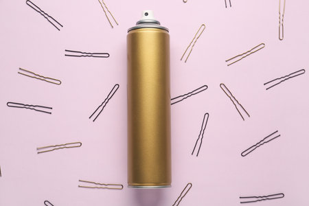 Composition with bottle of hair spray and pins on color backgroundの写真素材