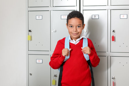 African-American little boy with backpack near locker at schoolの写真素材