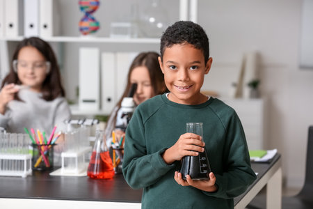 African-American little boy with conical flask in science classroomの写真素材