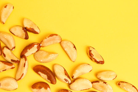 Delicious brazil nuts on yellow backgroundの写真素材