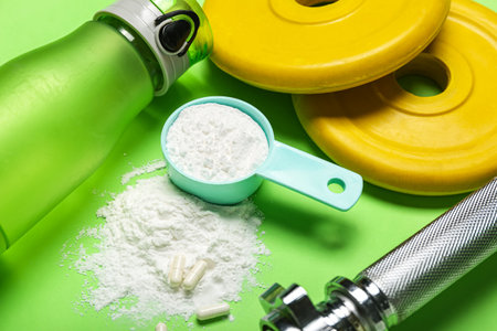 Scoop with amino acids, bottle of water and barbell supplement plates on color background, closeupの写真素材