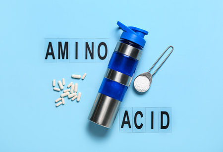 Text AMINO ACID, pills, powder and bottle of water on color backgroundの写真素材