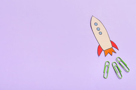 Paper rocket with clips on purple backgroundの写真素材