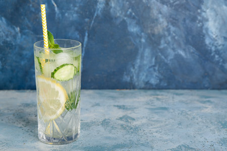 Glass of mojito with cucumber on grunge light blue tableの写真素材