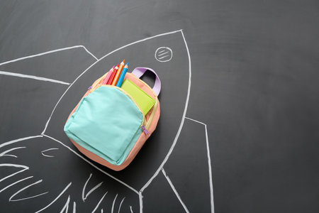Drawn rocket with backpack and pencils on black backgroundの写真素材