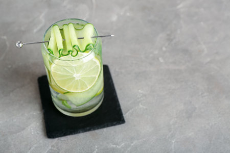Glass of mojito with cucumber on grunge gray tableの写真素材