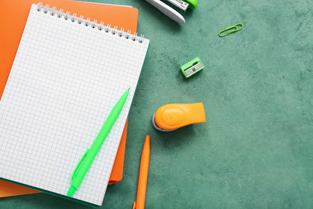 Blank notebook and stationery on grunge green backgroundの写真素材