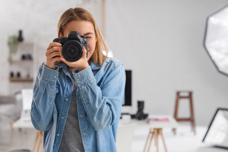 Female photographer with professional camera in studioの写真素材