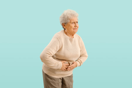 Senior woman with appendicitis on blue backgroundの写真素材
