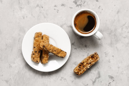 Plate with tasty biscotti cookies and cup of coffee on gray tableの写真素材