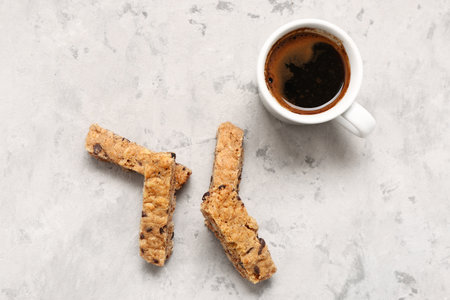 Tasty biscotti cookies and cup of coffee on gray tableの写真素材