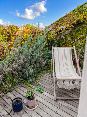 Open balcony with deck chair and plants in cityの写真素材