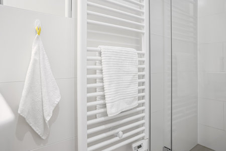Heated towel rail near light wall in bathroomの写真素材