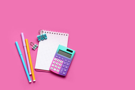 Modern calculator with stationery on pink background