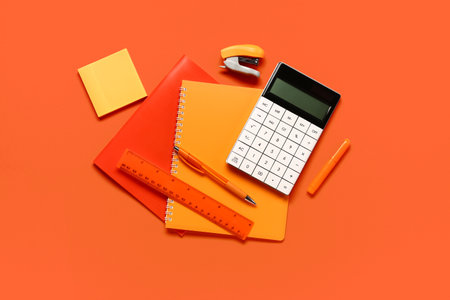 Modern calculator with stationery on orange backgroundの写真素材
