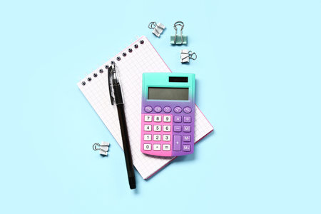 Modern calculator with stationery on blue background