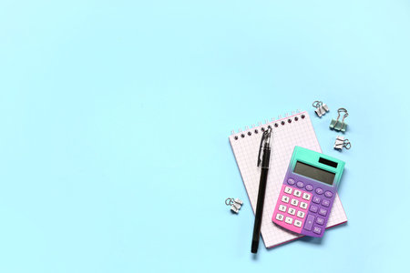 Modern calculator with stationery on blue background