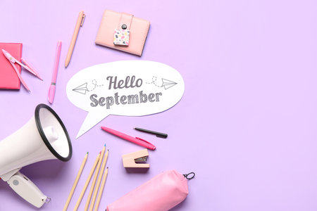 Different stationery, megaphone and speech bubble with text HELLO SEPTEMBER on lilac backgroundの写真素材