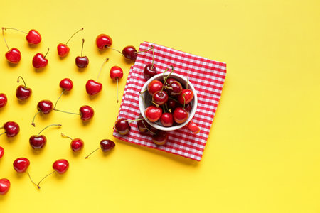 Cup with sweet cherry on yellow backgroundの写真素材