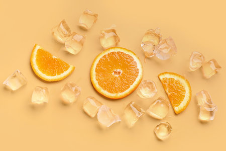 Orange slices with ice cubes on color backgroundの写真素材
