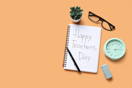 Notebook with text HAPPY TEACHERS DAY, alarm clock and eyeglasses on orange backgroundの写真素材