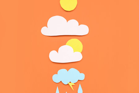 Paper sun with clouds and rain drops on red background. weather forecast concept