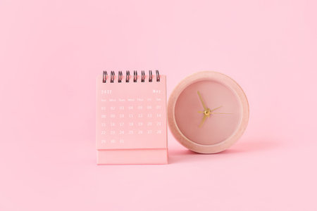 Flip paper calendar for May and alarm clock on pink backgroundの写真素材