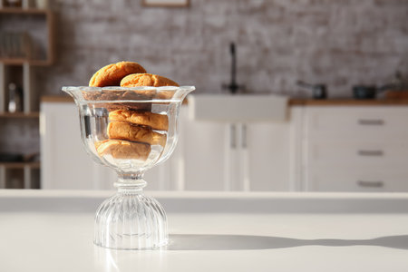 Glass bowl with tasty cookies on table in kitchenの写真素材