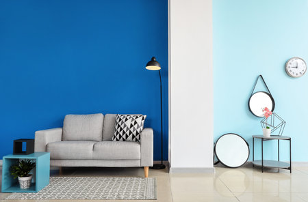 Comfortable sofa and mirrors in interior of living roomの写真素材