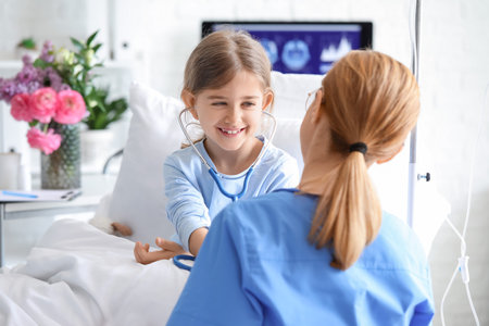 Female doctor working with little girl in hospital roomの写真素材