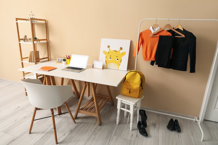 Stylish interior of children's room with modern laptop and school uniformの写真素材
