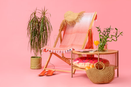 Deckchair with table and beach accessories on pink background. travel conceptの写真素材
