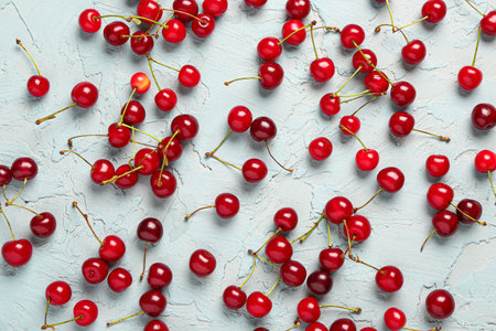 Many red sweet cherries on blue backgroundの写真素材