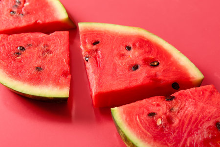 Pieces of fresh watermelon on red background