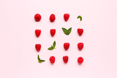 Many fresh raspberries and mints on pink background