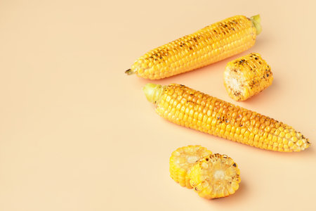 Tasty grilled corn cobs on orange backgroundの写真素材
