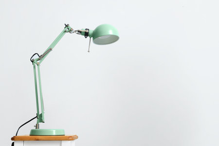 Modern lamp on table against light backgroundの写真素材
