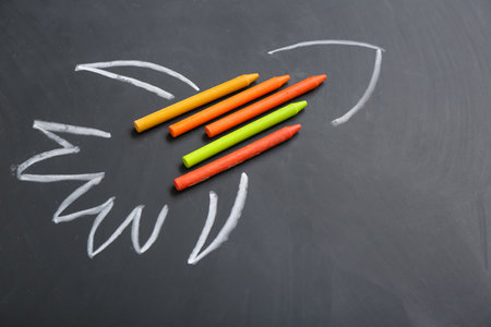 Drawn rocket with wax pencils on black backgroundの写真素材