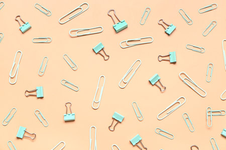 Colorful binder clips on beige backgroundの写真素材