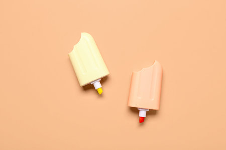Colorful markers in shape of ice cream on beige background