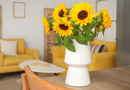 Vase with beautiful sunflowers on wooden table in kitchen, closeupの写真素材