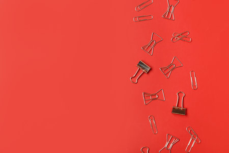 Paper clips and binders on red backgroundの写真素材