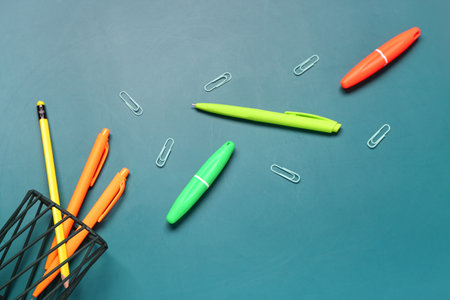 Holder with stationery and paper clips on blue backgroundの写真素材