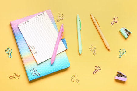Different school stationery and blank notebook on yellow background