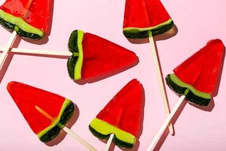 Lollipops in shape of watermelon slice on pink backgroundの写真素材