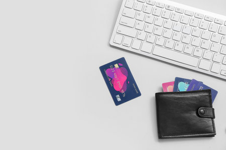 Keyboard with leather wallet and credit cards on gray backgroundの写真素材